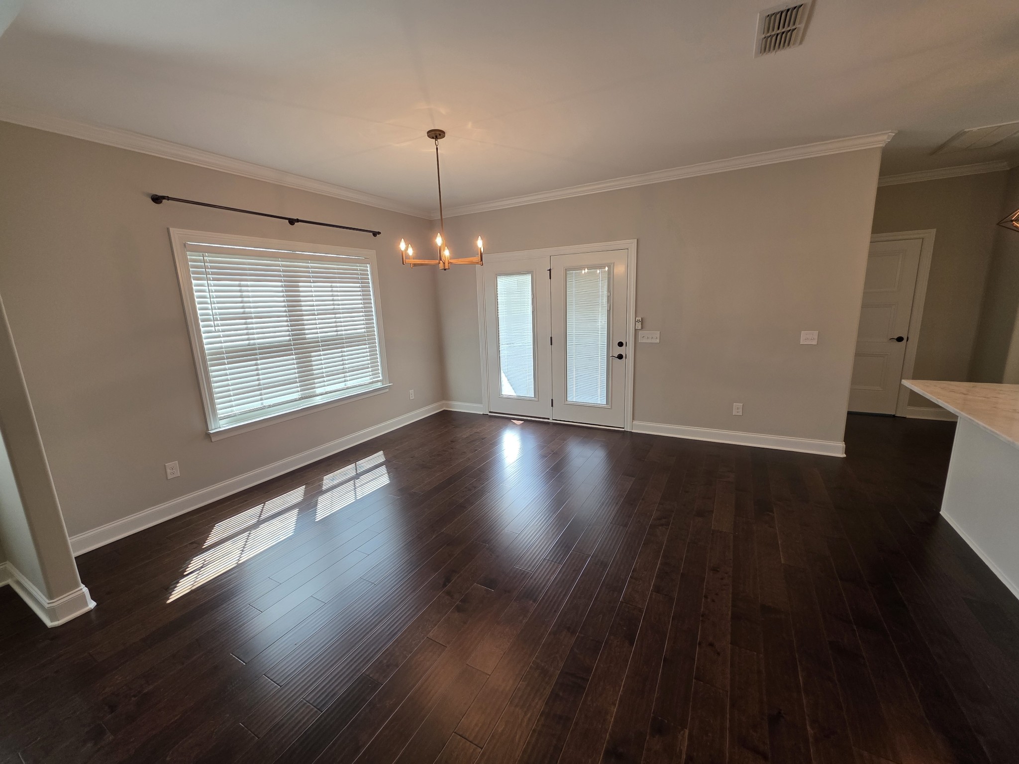 453 Ruby Oaks Lane Murfreesboro, TN 37128 - Photo 6 of 34 an empty room with wooden floor chandelier and windows