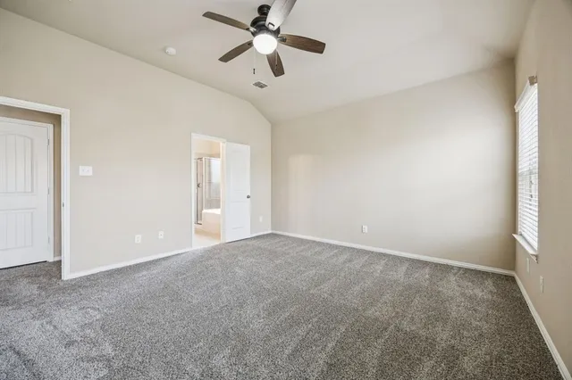 an empty room with windows and fan