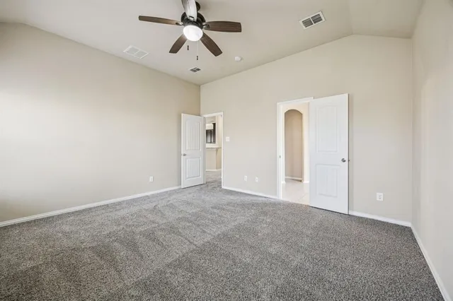 an empty room with chandelier fan