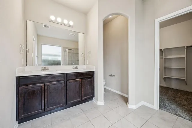 a bathroom with a double vanity sink and a mirror