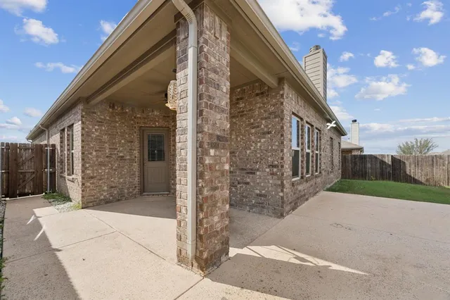 a view of a brick house next to a yard