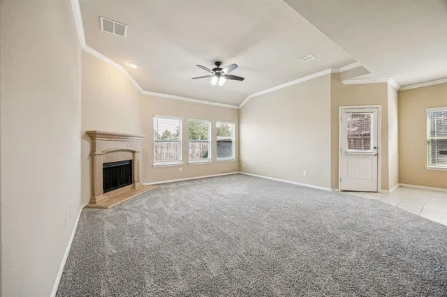 an empty room with windows and fireplace