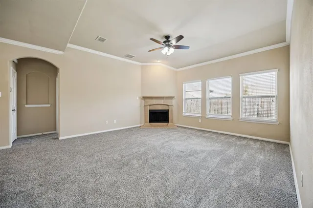 an empty room with windows and fireplace