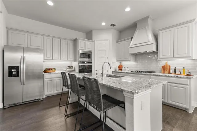 a kitchen with stainless steel appliances granite countertop a sink stove and cabinets