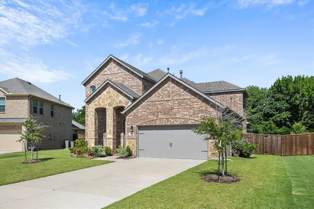a front view of a house with a garden and plants