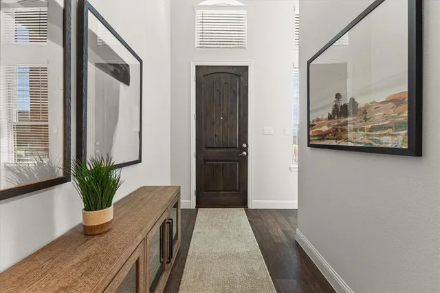 a view of a hallway to a livingroom with furniture
