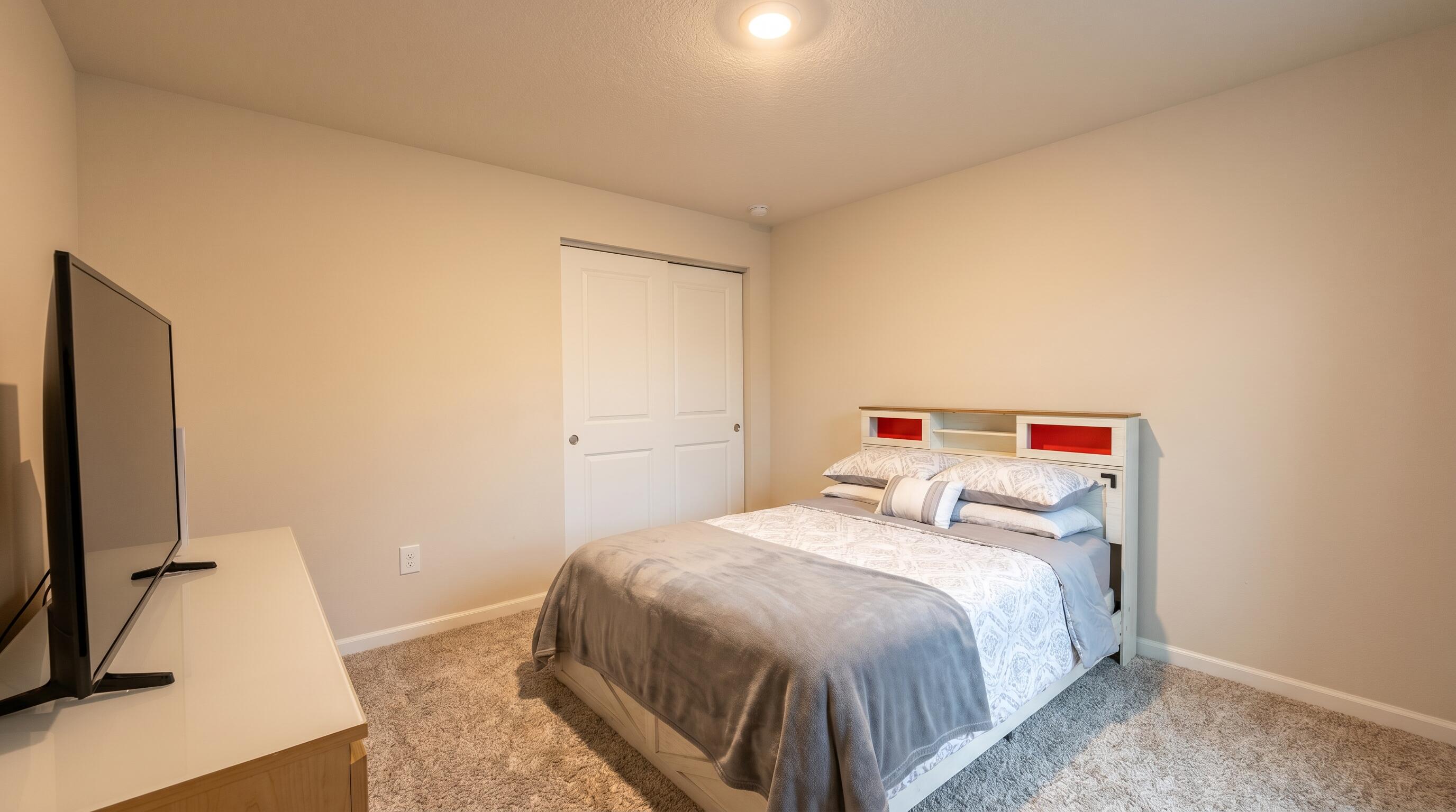 5784 Southeast Edgewater Circle Stuart, FL 34997 - Photo 14 of 33 a bedroom with a bed and a flat tv screen on a dresser