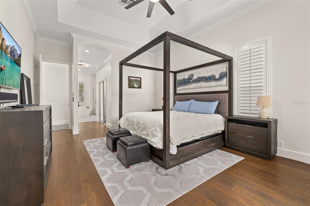 8351 Bowden Way Windermere, FL 34786 - Photo 21 of 71 a bedroom with a bed a couch and a flat tv screen on the dresser