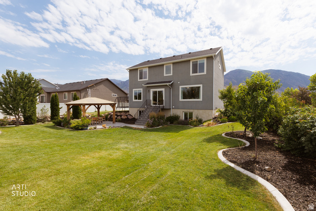 1654 South 730 West Provo, UT 84601 - Photo 32 of 33 Expansive backyard featuring a large lawn, a wooden gazebo with a stone patio, mature landscaping, and a multi-level deck with stairs leading to the yard
