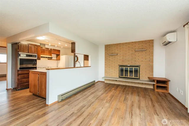 a view of kitchen living room with wooden floor and fireplace