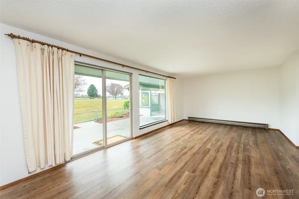a view of an empty room and wooden floor and glass door
