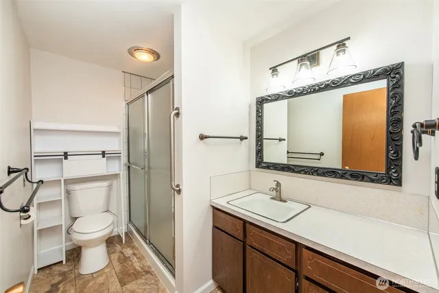 a bathroom with a sink a toilet and shower