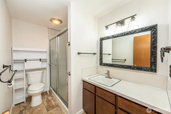 a bathroom with a sink a toilet and shower