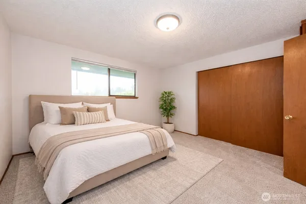 a bedroom with a bed potted plant and a window