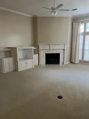 an empty room with a fireplace and windows