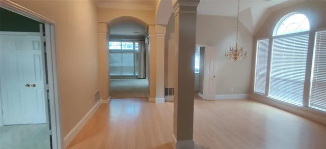 a view of a hallway with wooden floor and closet