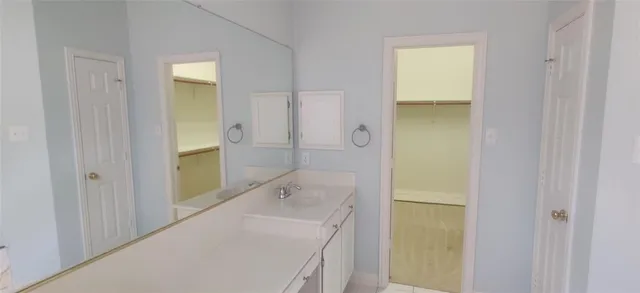 a bathroom with a granite countertop sink a mirror and a bathtub