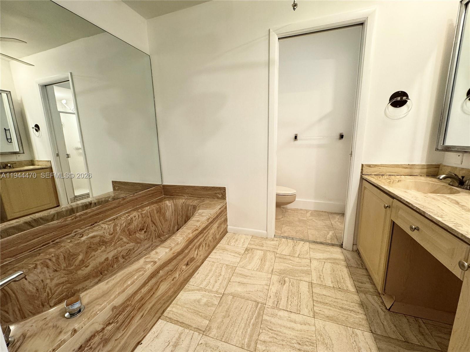 2001 St Andrews Road, Unit 121 Hollywood, FL 33021 - Photo 22 of 39 a bathroom with a sink a toilet and a mirror