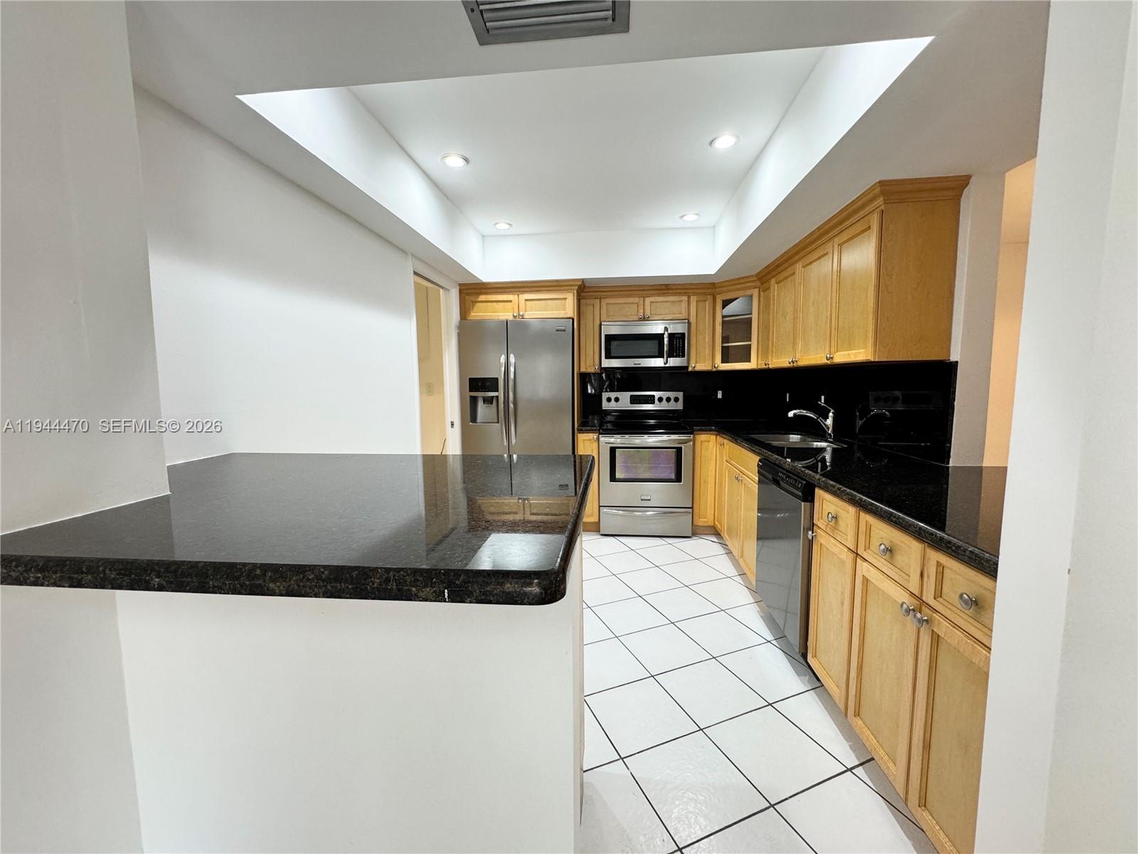 2001 St Andrews Road, Unit 121 Hollywood, FL 33021 - Photo 27 of 39 a large kitchen with stainless steel appliances a large counter top a stove and a refrigerator