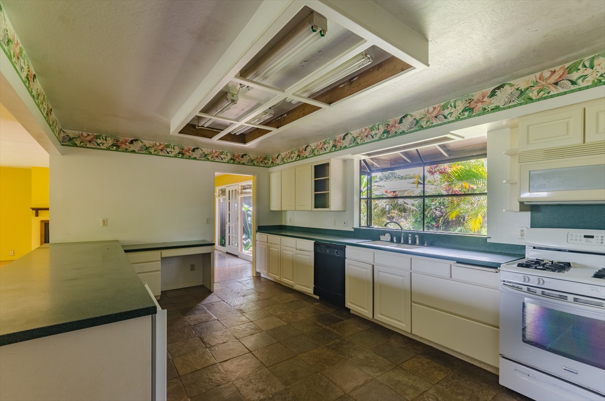 4110 Koloa Road Koloa, HI 96756 - Photo 12 of 18 a kitchen with stainless steel appliances granite countertop a sink a stove and a microwave