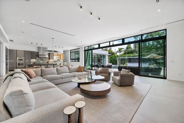 a large kitchen with stainless steel appliances a large counter top a stove and a sink