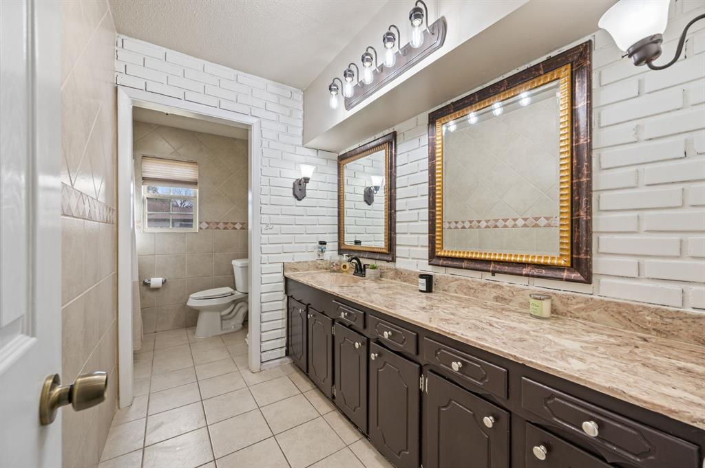 2125 Shady Brook Drive Bedford, TX 76021 - Photo 16 of 24 a spacious bathroom with a granite countertop sink mirror and a toilet