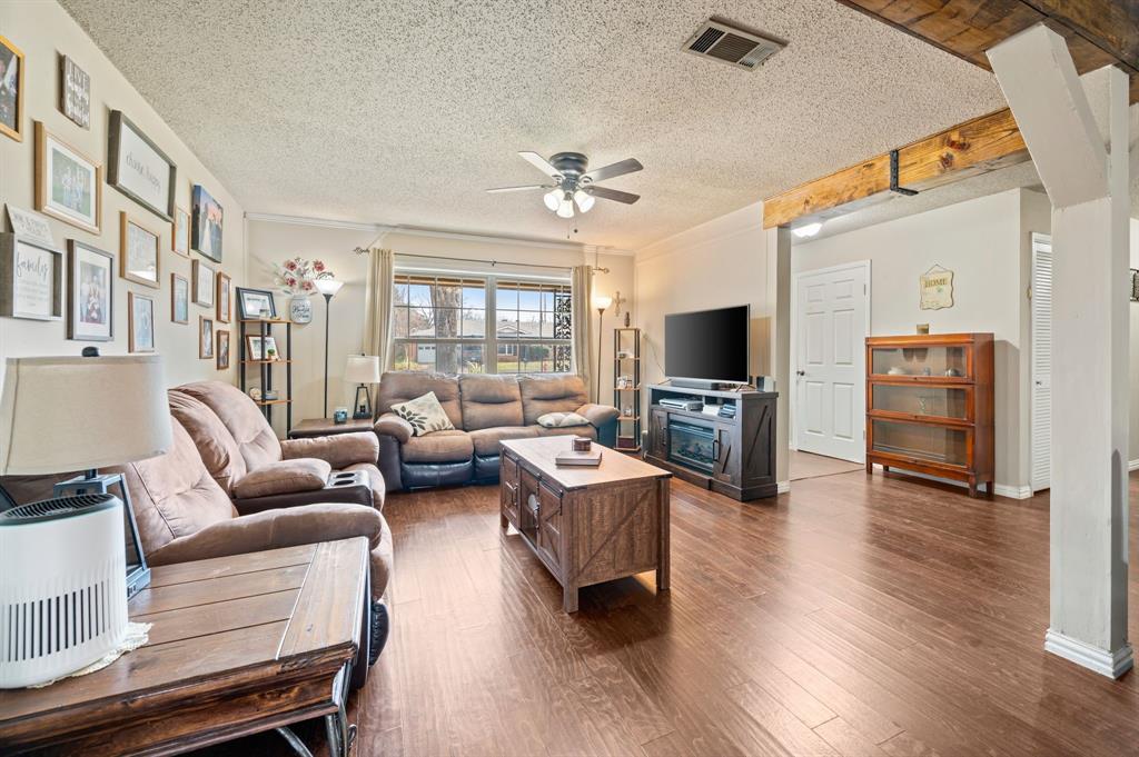 2125 Shady Brook Drive Bedford, TX 76021 - Photo 2 of 24 a living room with furniture flat screen tv and wooden floor