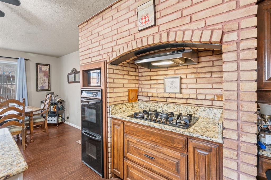 2125 Shady Brook Drive Bedford, TX 76021 - Photo 8 of 24 a kitchen with a stove and wooden cabinets