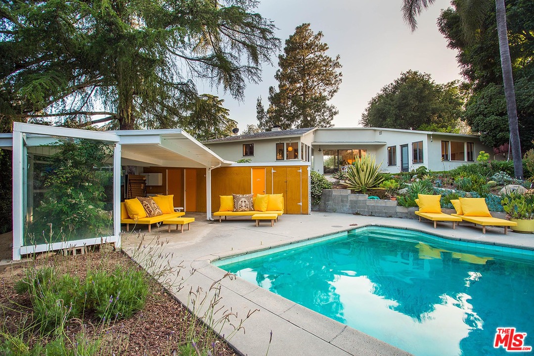 a view of a house with swimming pool and porch with furniture