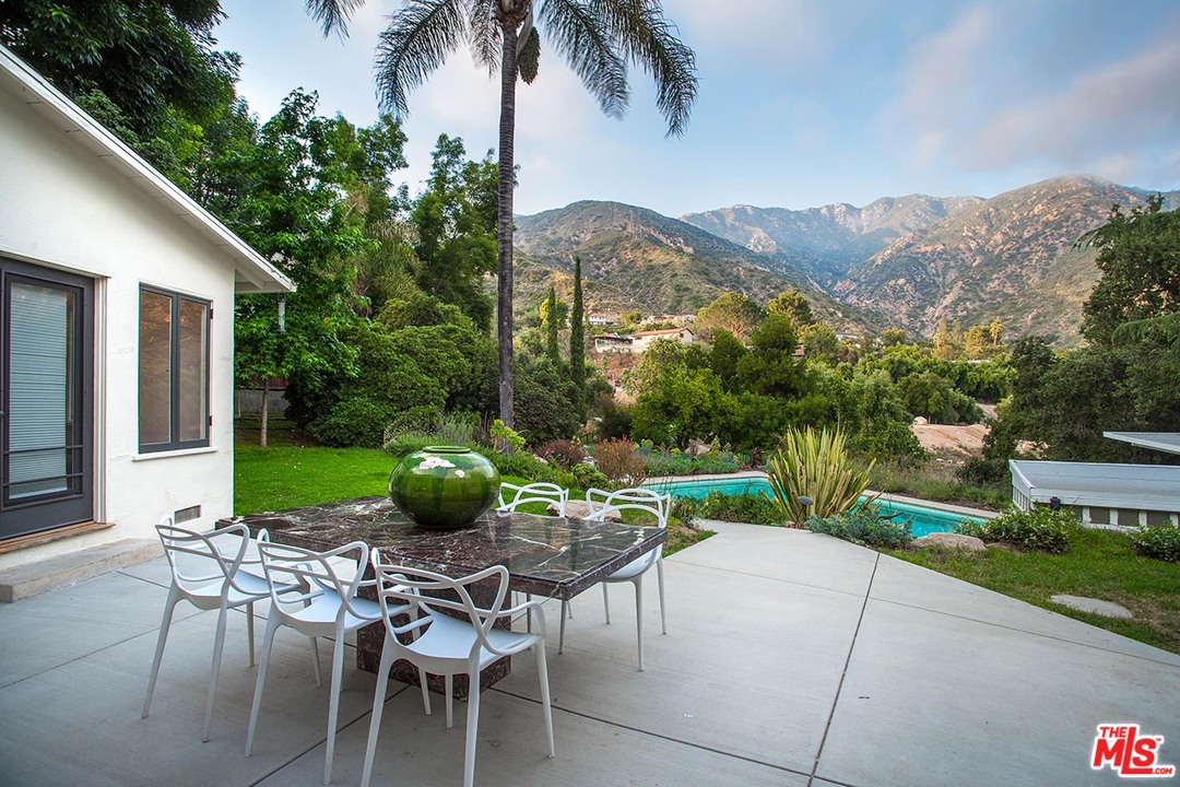 1081 Alta Pine Drive Altadena, CA 91001 - Photo 16 of 38 a view of a patio with a table and chairs under an umbrella
