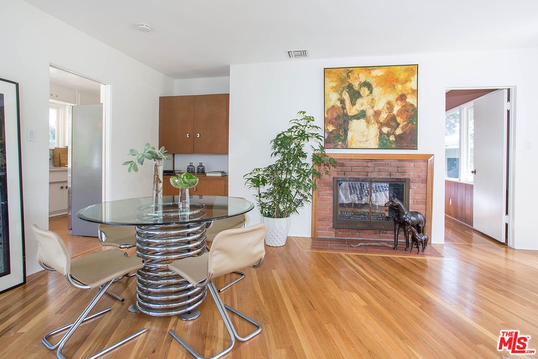 1081 Alta Pine Drive Altadena, CA 91001 - Photo 6 of 38 a dining room with furniture a fireplace and wooden floor