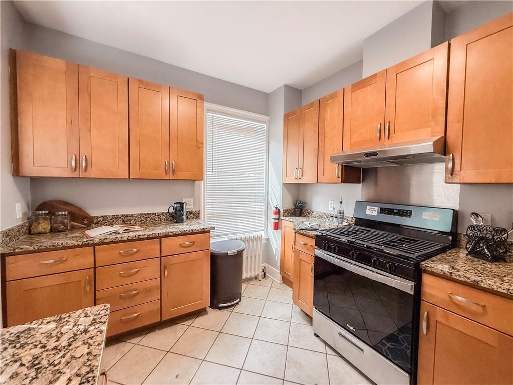 5642 Solway Street Pittsburgh, PA 15217 - Photo 11 of 28 a kitchen with stainless steel appliances granite countertop a stove a sink and a microwave