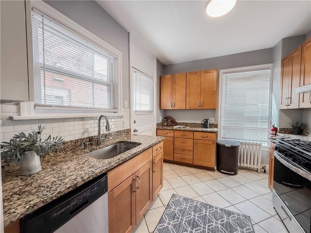 5642 Solway Street Pittsburgh, PA 15217 - Photo 12 of 28 a kitchen with a sink stove top oven and cabinets