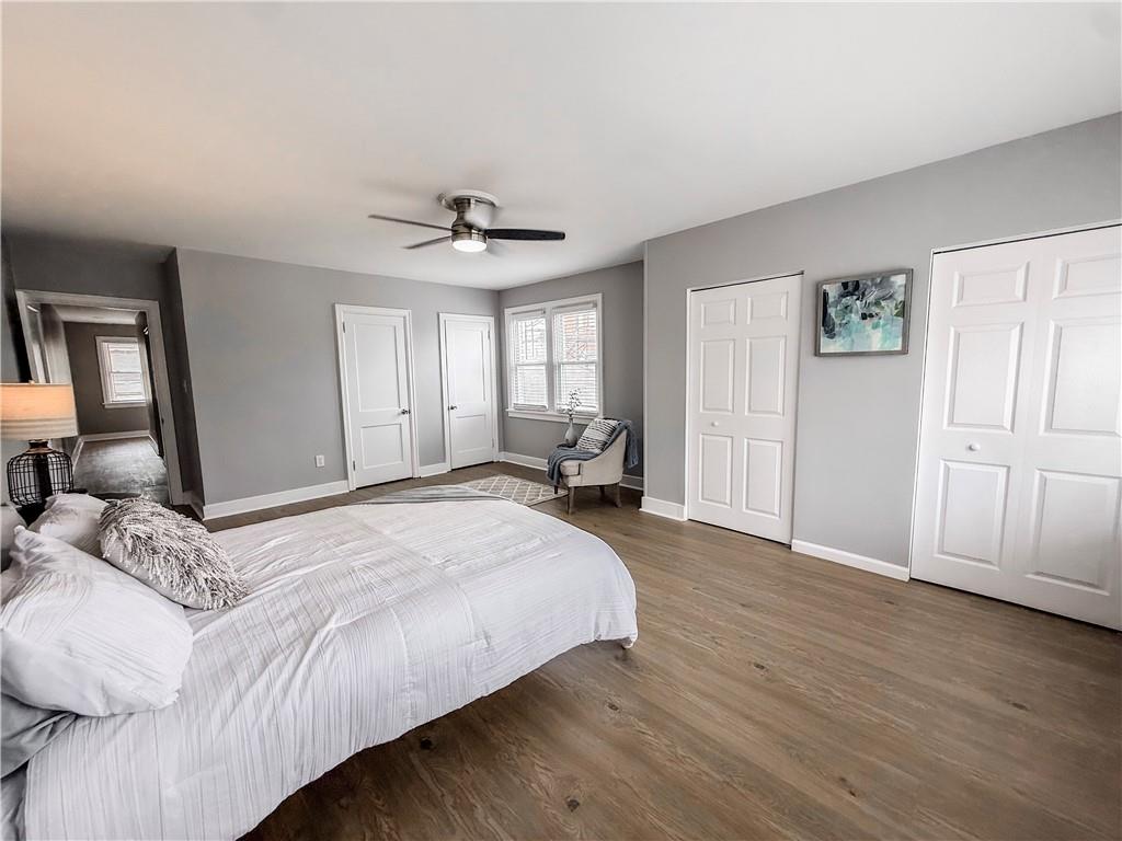 5642 Solway Street Pittsburgh, PA 15217 - Photo 19 of 28 a spacious bedroom with a bed and dresser with wooden floor
