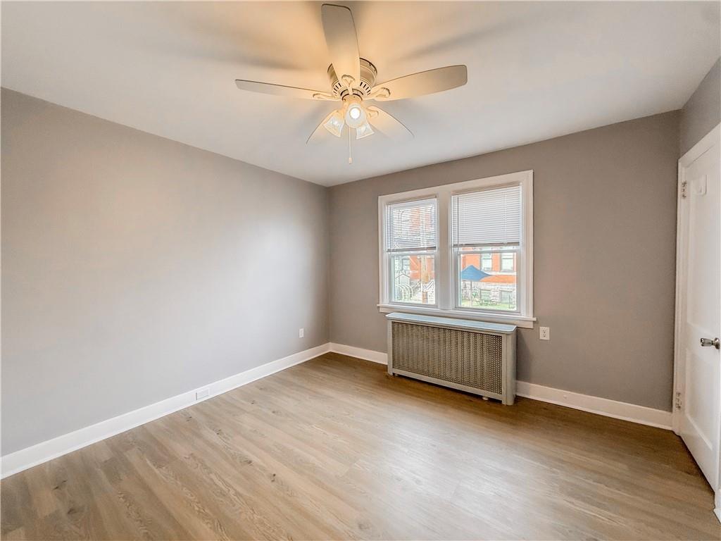 5642 Solway Street Pittsburgh, PA 15217 - Photo 21 of 28 an empty room with chandelier fan and windows