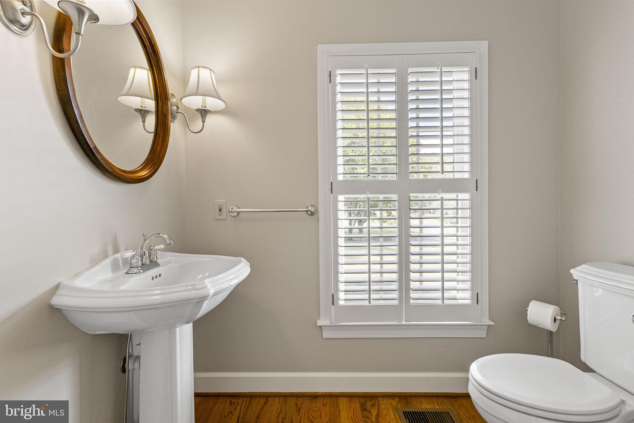 15906 Barnesville Road Boyds, MD 20841 - Photo 29 of 57 a bathroom with a sink a mirror a toilet and a window