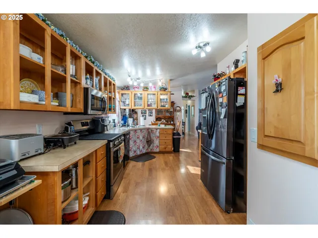 a kitchen with stainless steel appliances granite countertop a refrigerator a stove and a sink