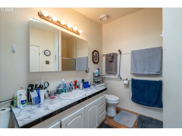a bathroom with a granite countertop sink mirror vanity and toilet