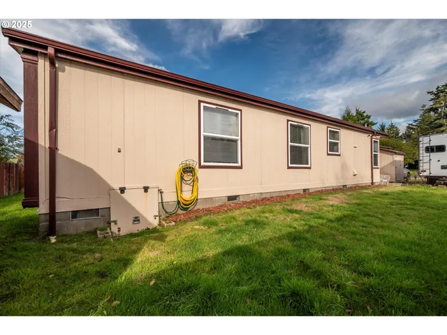 a backyard of a house with plants and large tree