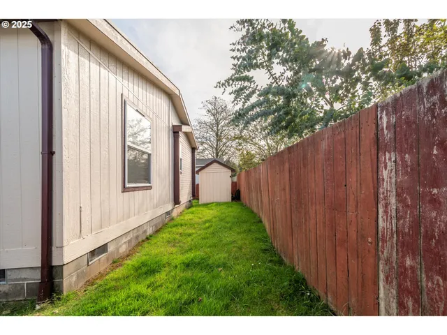 a view of backyard with potted plants and wooden fence