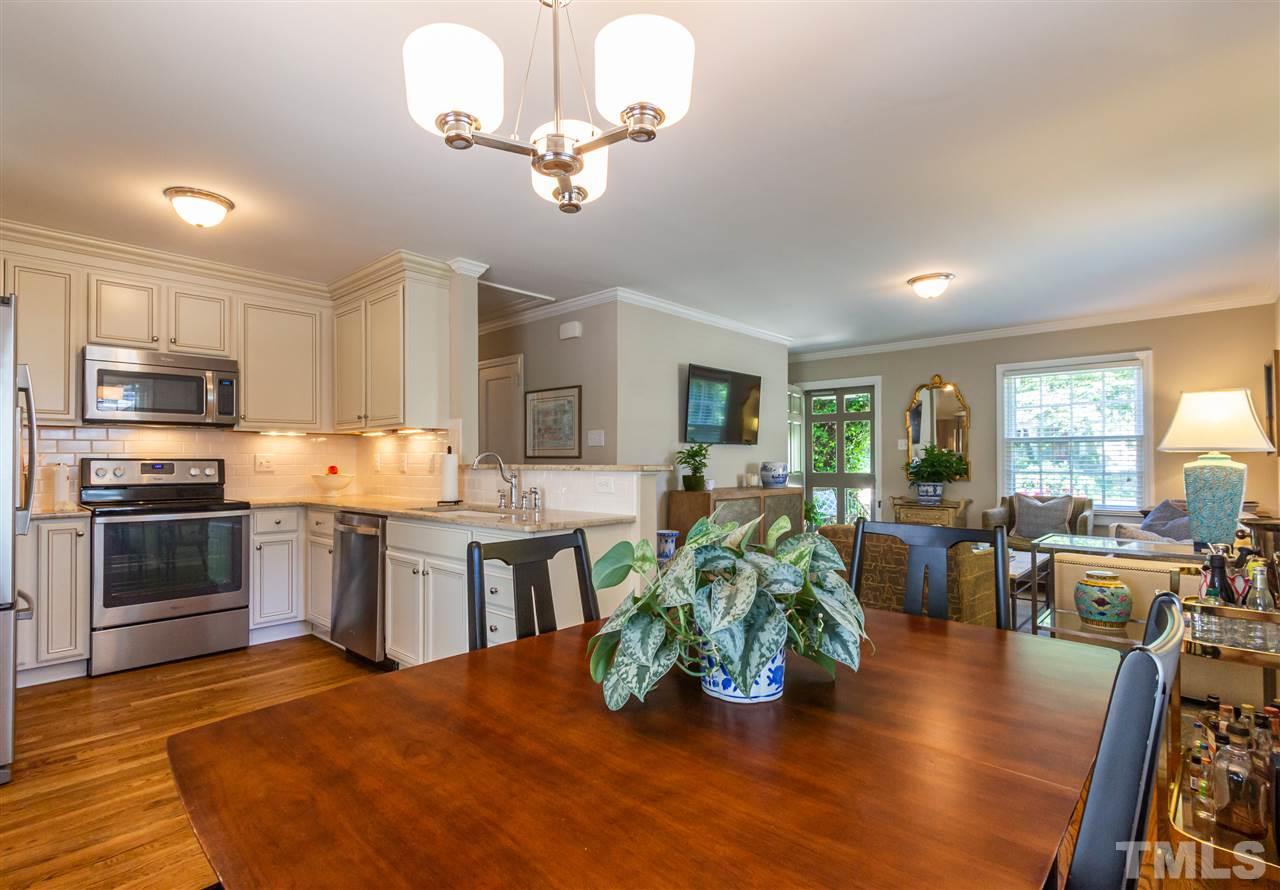 1230 Clifton Street Raleigh, NC 27604 - Photo 5 of 19 a kitchen with stainless steel appliances granite countertop a stove refrigerator a dining table and chairs with wooden floor