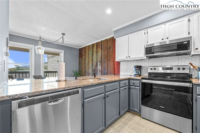 a kitchen with stainless steel appliances granite countertop a sink and stove top oven
