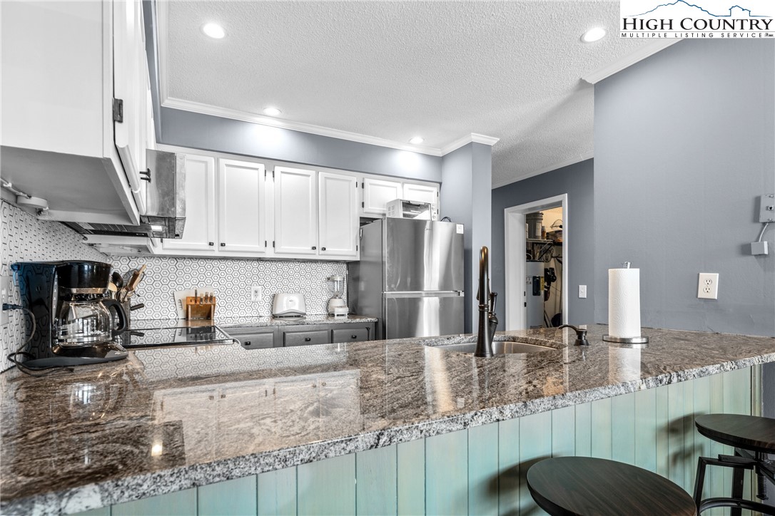 301 Pinnacle Inn Road, Unit 3207 Beech Mountain, NC 28604 - Photo 9 of 37 a kitchen with stainless steel appliances granite countertop a sink refrigerator and cabinets