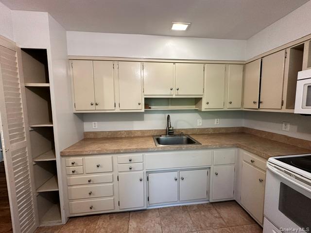 97 Cold Spring Road Stanfordville, NY 12581 - Photo 9 of 16 L-shaped kitchen featuring cream cabinetry, and a built-in pantry with louvered doors