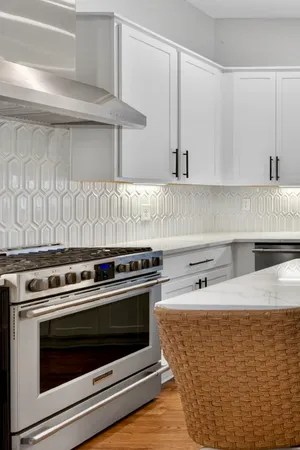 a large kitchen with kitchen island a large island a sink a stove and wooden floors