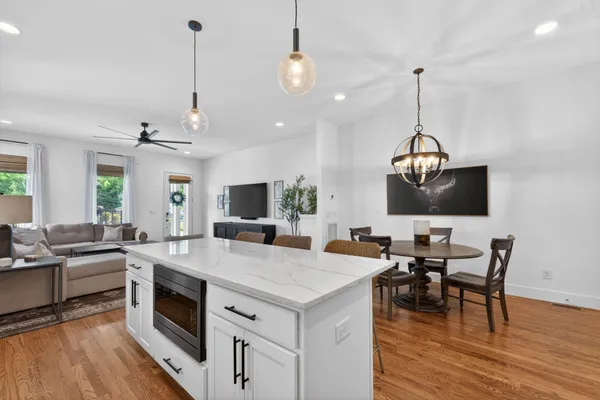 a view of a dining room with furniture a chandelier and wooden floor