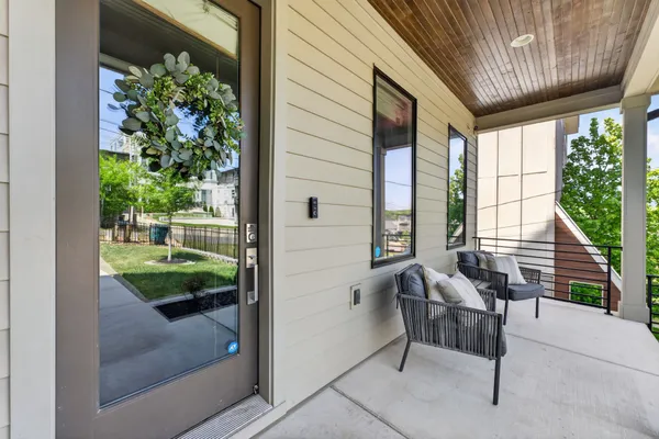 a view of a balcony with wooden floor next to a yard