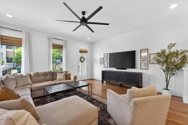 a living room with furniture and a wooden floor