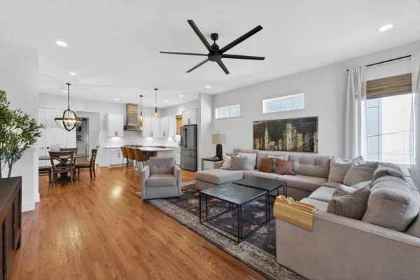 a living room with furniture and a flat screen tv with kitchen view