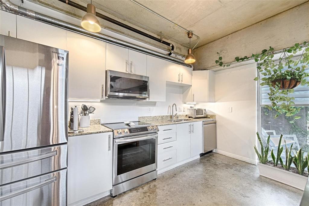 1001 Belleview Street, Unit 104 Dallas, TX 75215 - Photo 11 of 22 a kitchen with stainless steel appliances granite countertop a refrigerator sink and stove